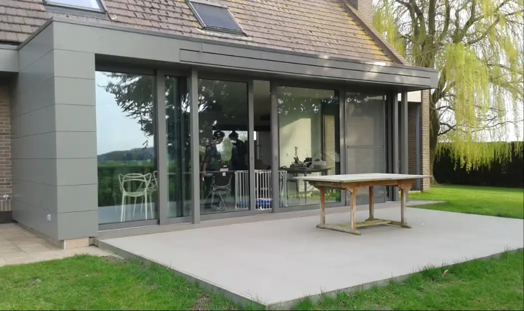 Extension vitrée avec terrasse et table en bois