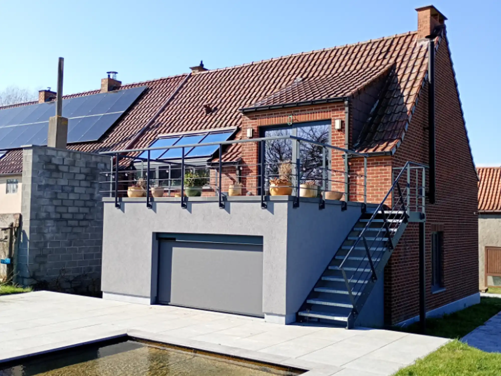 Extension avec garage, terrasse et plan d'eau après rénovation